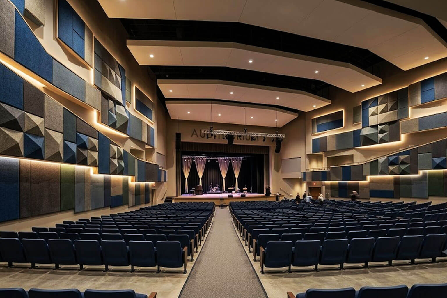 Fabric acoustic wall panels installed in auditorium for echo reduction sound absorption and improved speech intelligibility