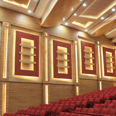 Auditorium acoustic treatment with sound-absorbing wall panels